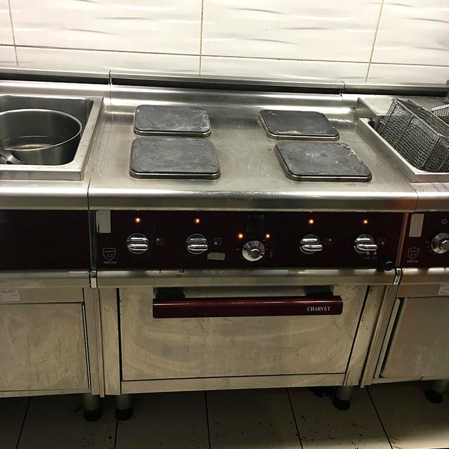 Professional gas cooking range with oven installed in a commercial kitchen