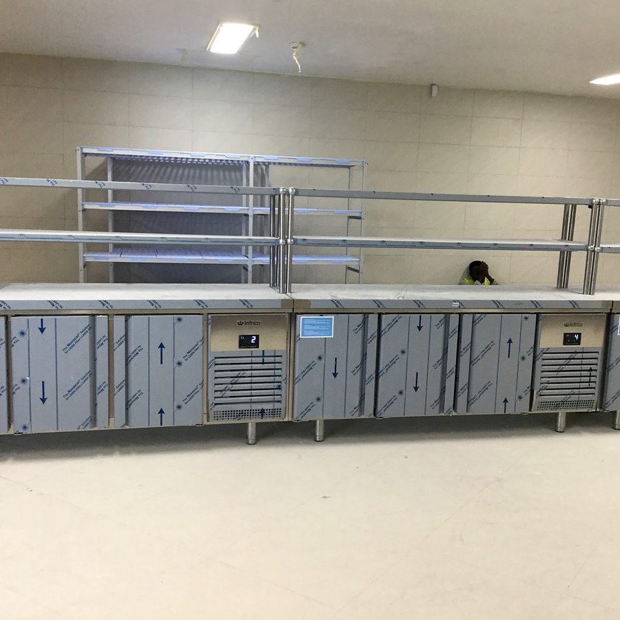 Refrigerated preparation counters and overshelf installed in a professional kitchen